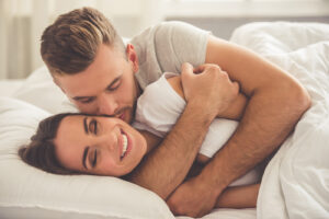 a man and woman cuddling in bed